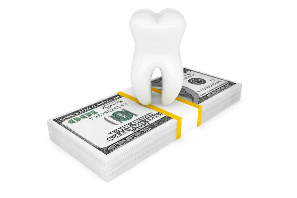 a tooth atop a stack of bills | dental cleanings highpoint nc