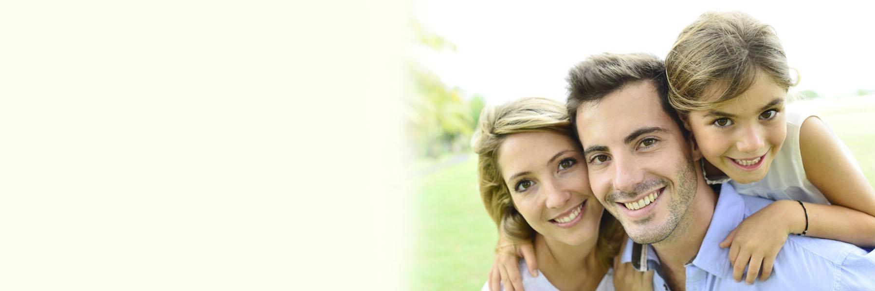 Young family of three smiling after dental check up in High Point, NC