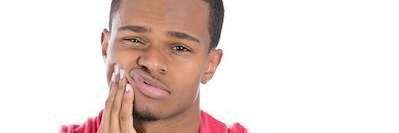 A patient holding his jaw due to toothache in High Point, NC 