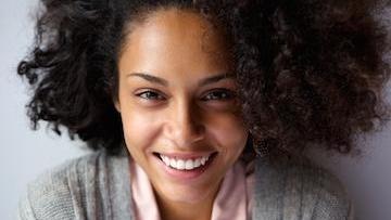 Woman with curly hair smiling l cosmetic dentist in high point