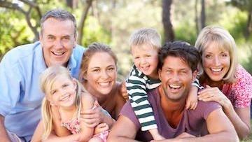 Young multi-generational family smiling after dental check up in High Point, NC