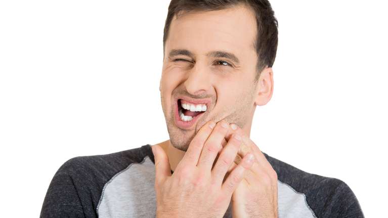 A patient holding his jaw due to toothache in High Point, NC 